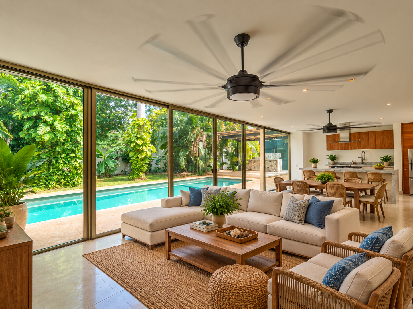 Open plan living area with a white sectional sofa wood coffee table and glass walls overlooking a pool and tropical garden
